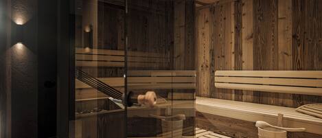 A sauna with wooden benches and a glass partition.