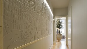 Un couloir doté d’un plancher en bois et d’un panneau décoratif mural.