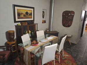 Enjoy meals in this inviting dining area with a glass table, comfortable chairs, and a traditional stove.