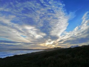 Experience the serene coastal landscape with dramatic skies and rugged shoreline.