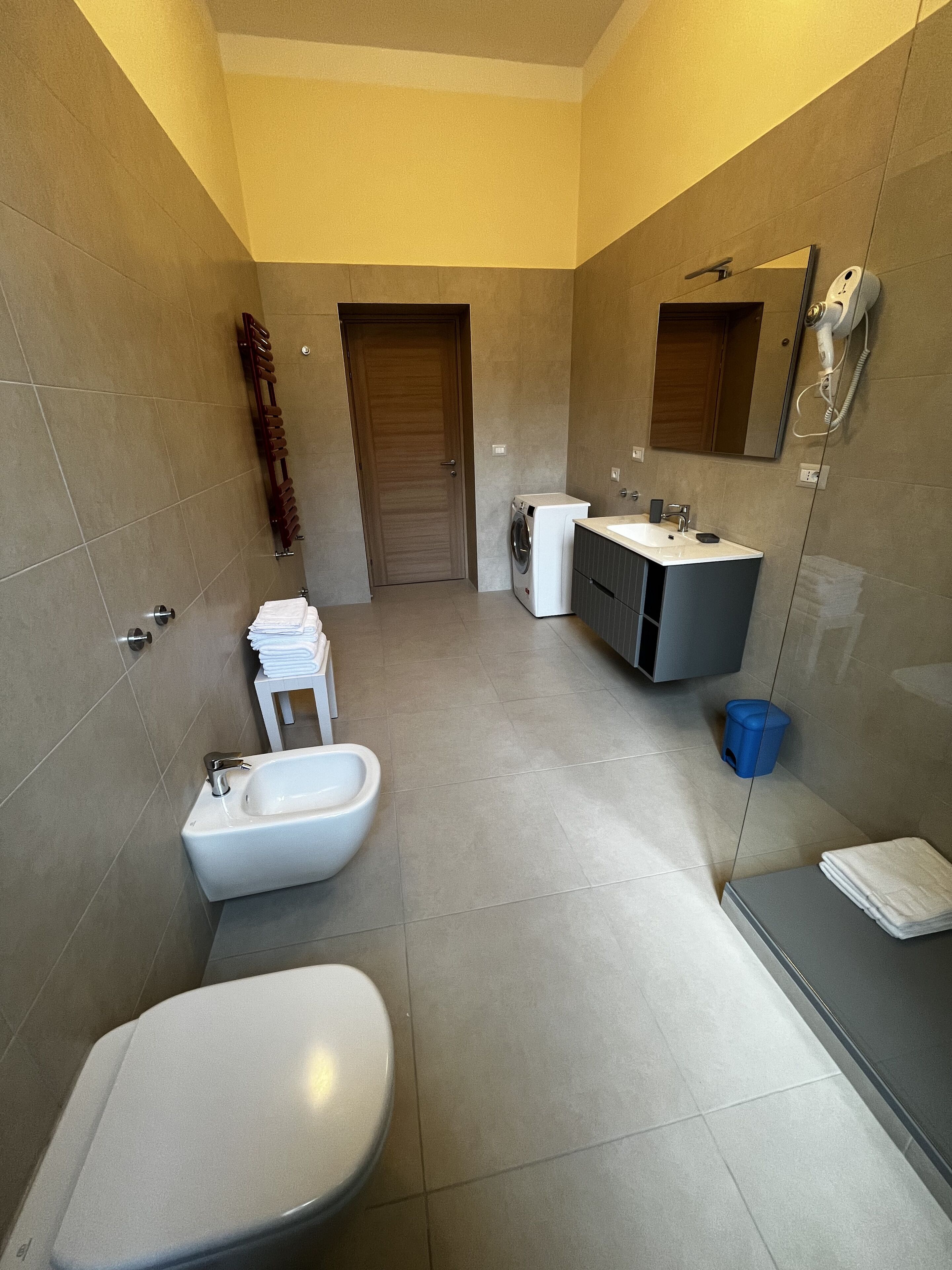 Un baño moderno con inodoro, bidé, lavabo y espejo.