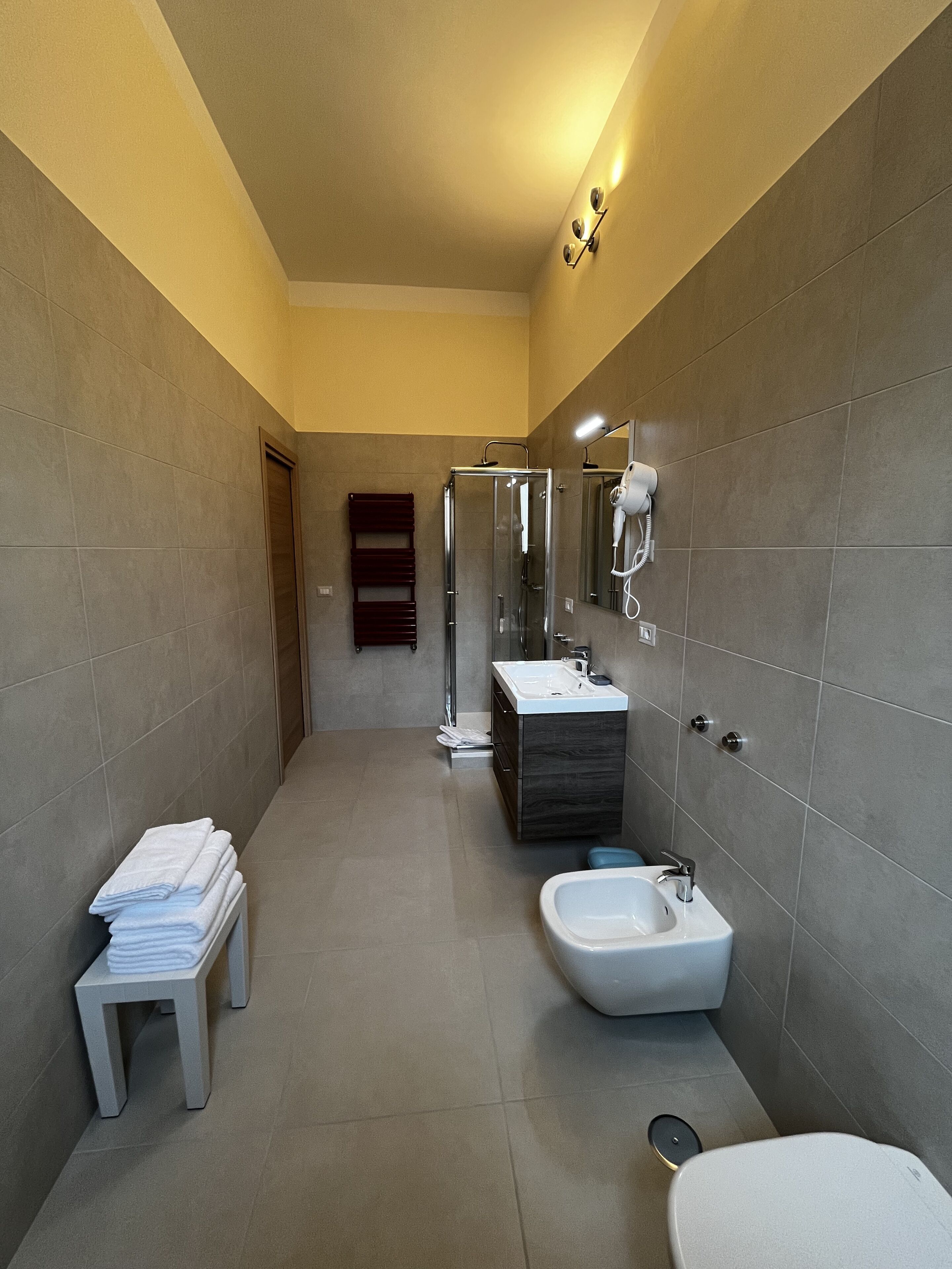 Une salle de bain moderne avec une douche à l’italienne, un meuble-lavabo et des toilettes.