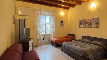 A bedroom with a wooden ceiling, a bed, a sofa, a desk, and a window with curtains.