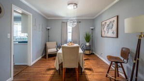 A dining area with a table set for four, a chandelier, a potted plant, and a world map on the wall. - Beautiful Spacious Home- Near the Expo, TU, gathering Place, Fair park (Tulsa)