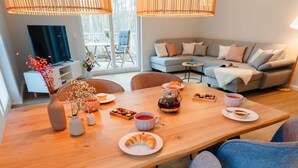Un comedor con una mesa de madera, sillas y un sofá al fondo.