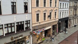 A street view with a bank, a colorful storefront, and pedestrians.