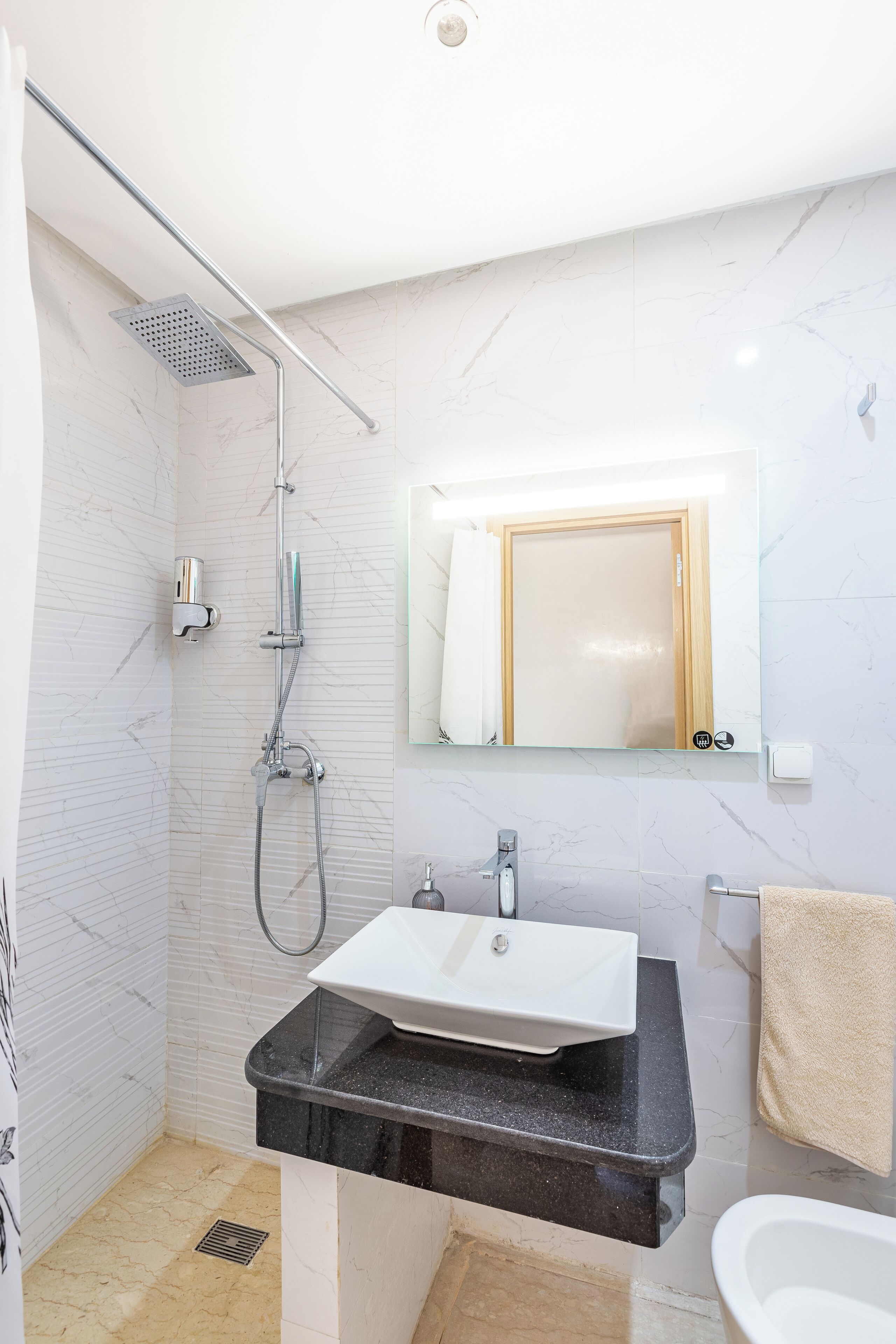 Un baño moderno con ducha, lavamanos e inodoro.