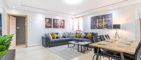 Una sala moderna con sofá, mesa de centro, mesa de comedor y sillas.