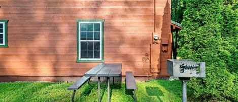Una casa de madera con una mesa de picnic y un buzón.