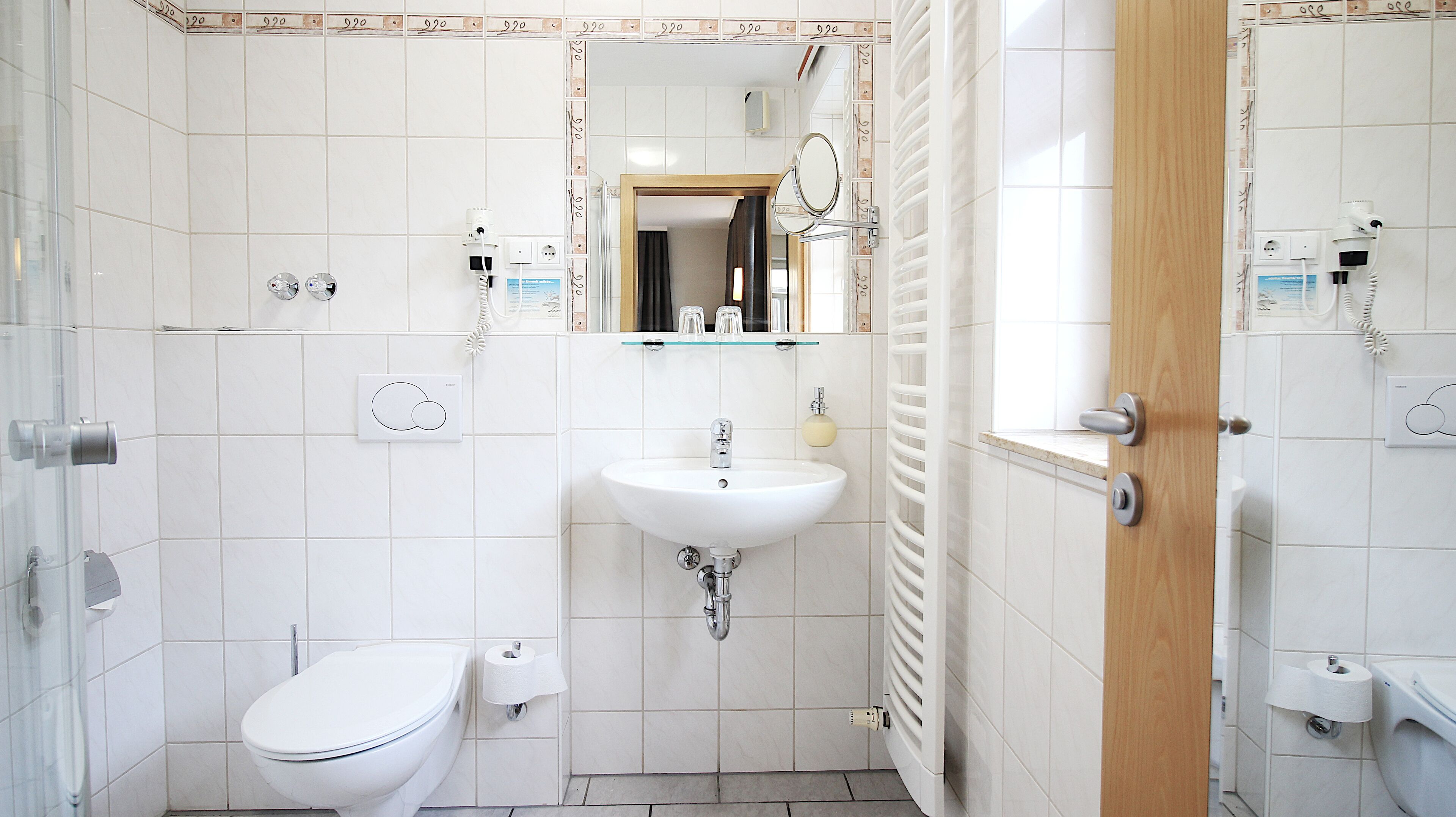 A modern bathroom with a toilet, sink, and shower.