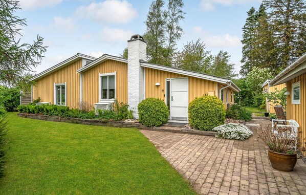 A two-story wooden house with a brick pathway leading to the entrance. - Cozy home in Gilleleje with WiFi (Gilleleje)