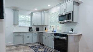 A modern kitchen with light grey cabinets, a stainless steel oven, and a microwave. - Modern 2BR King Bed near USC, Downtown & Ft Jackson (Columbia)