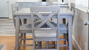 A modern kitchen with white cabinetry, a dining table with chairs, and a window with blinds. - Modern 2BR King Bed near USC, Downtown & Ft Jackson (Columbia)