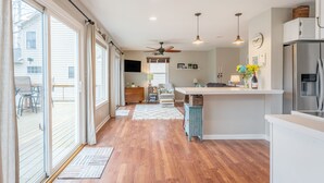 A spacious kitchen with a large island, sliding glass doors leading to a deck, and a ceiling fan. - Life on the Lake. Enjoy the peace and kayaks. (Locust Grove)