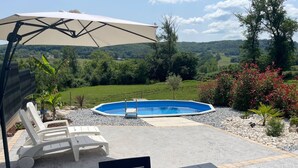 Ein Poolbereich mit Pool, Liegestühlen und einem Tisch.