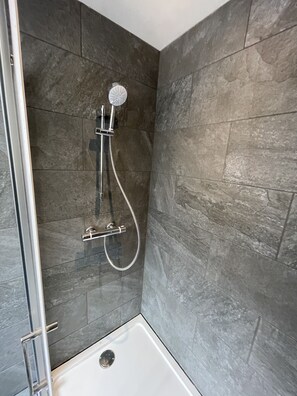Een douche, handdoeken, zeep, shampoo