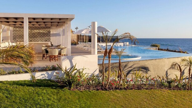 A modern resort with a pool, outdoor seating, and a view of the ocean. - Oceanfront at Cerritos Beach • Infinity Pool+Spa (Los Cerritos)