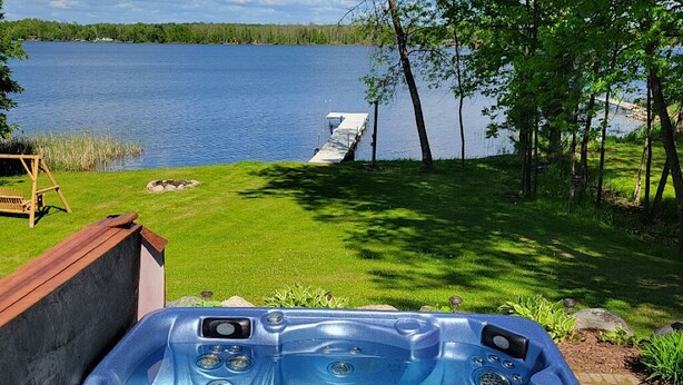 Un jacuzzi con vista a un lago y un muelle.