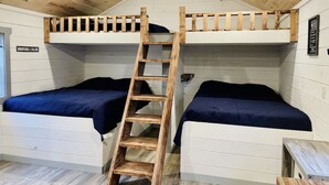 A bunk bed room with a wooden ladder, white walls, and a small table. - UTV/ATV PARADISE! A/C and heat  (Huntsville)