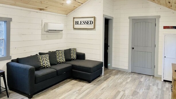 A cozy room with a sectional sofa, a wooden ceiling, and a door labeled "Tennessee". - UTV/ATV PARADISE! A/C and heat  (Huntsville)