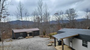 A two-story cabin with a gravel driveway and a covered porch. - UTV/ATV PARADISE! A/C and heat  (Huntsville)