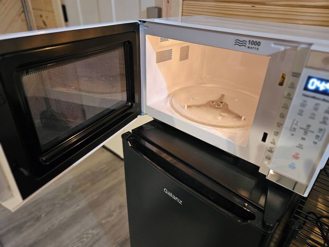 A compact microwave with a digital display and a black base.