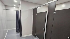 Un couloir avec des casiers et un espace douche.