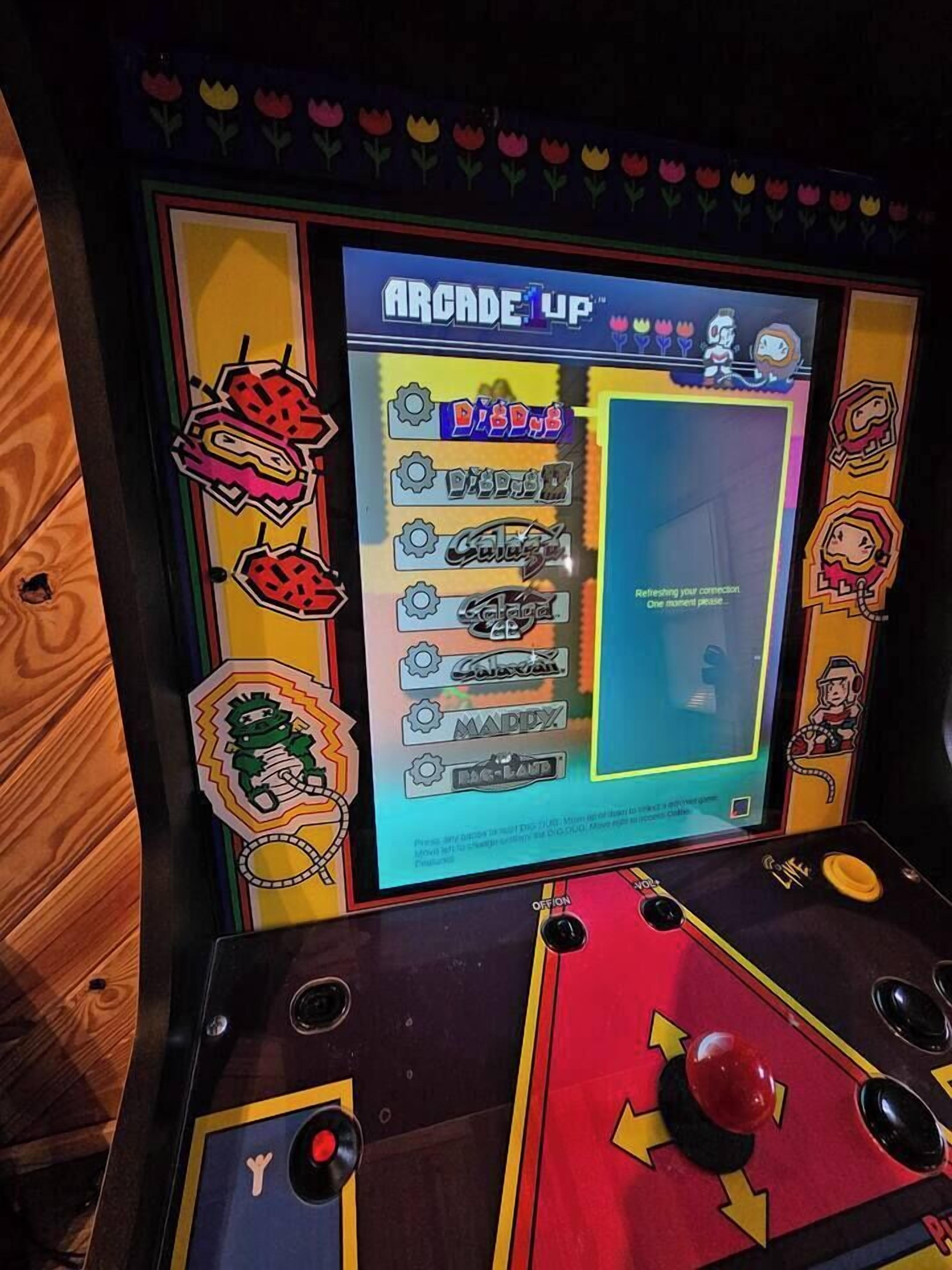 Una màquina recreativa antiga amb una pantalla colorida i controls de palanca.