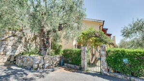 A stone wall, a gate, and a building with a balcony. - Beautiful home in Diano Calderina (Diano Calderina)