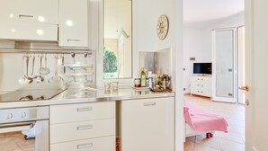 A modern kitchen with stainless steel appliances, a hanging pot rack, and a large mirror. - Beautiful home in Diano Calderina (Diano Calderina)