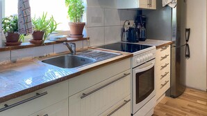 Una cocina con un lavamanos de acero inoxidable, horno empotrado y cafetera.