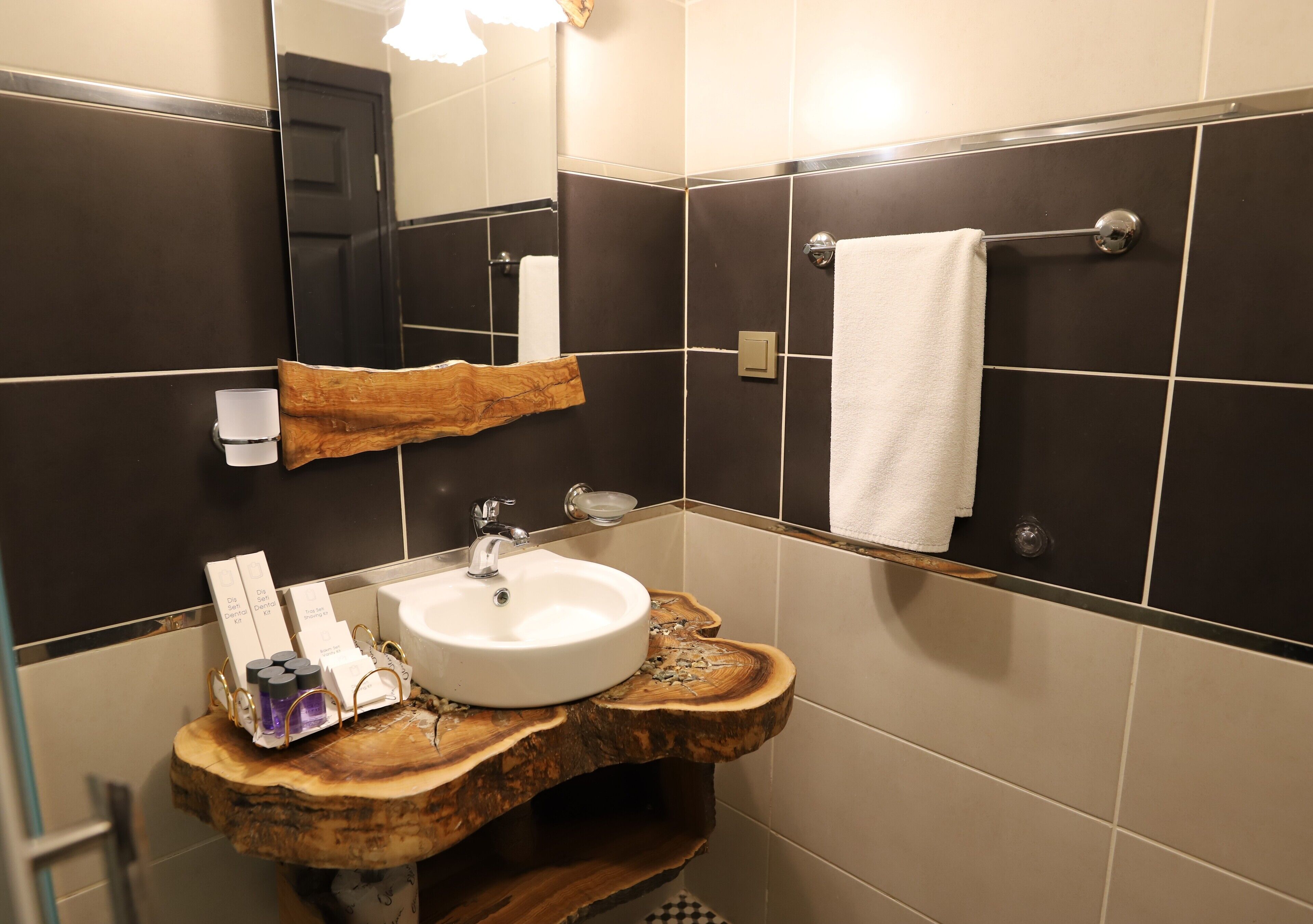 A bathroom with a wooden sink, a mirror, and a towel rack.