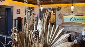 Un intérieur rustique avec un escalier en bois, des lanternes décoratives et une enseigne portant l’inscription « Chez Olivia ».
