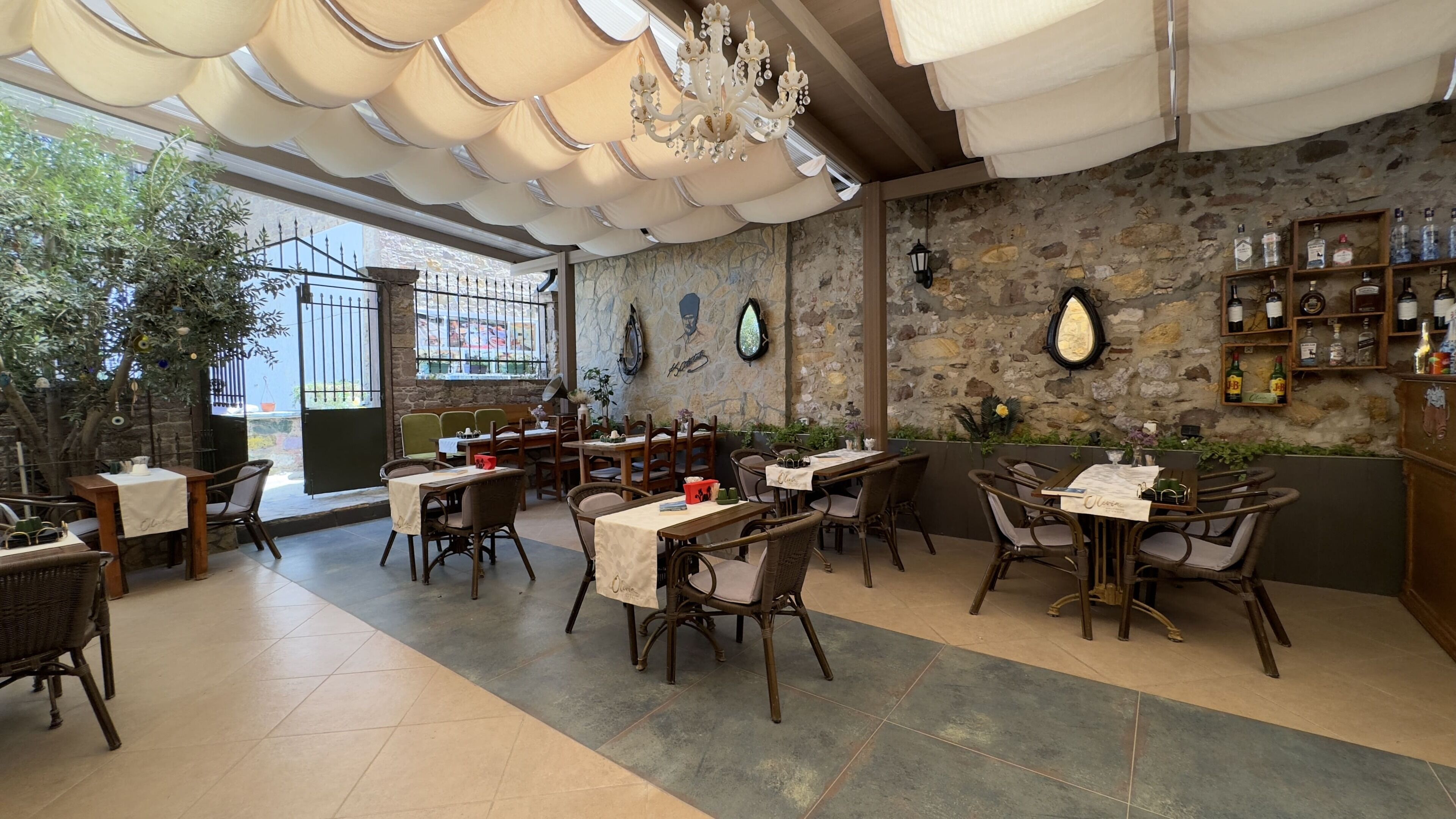 Ein Restaurant mit Steinwänden, Holzmöbeln und verschiedenen Tischgestaltungen.