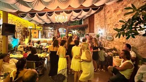 Un espace intérieur bondé, avec un mur en pierre rustique, un plafond décoré de tentures et un lustre.