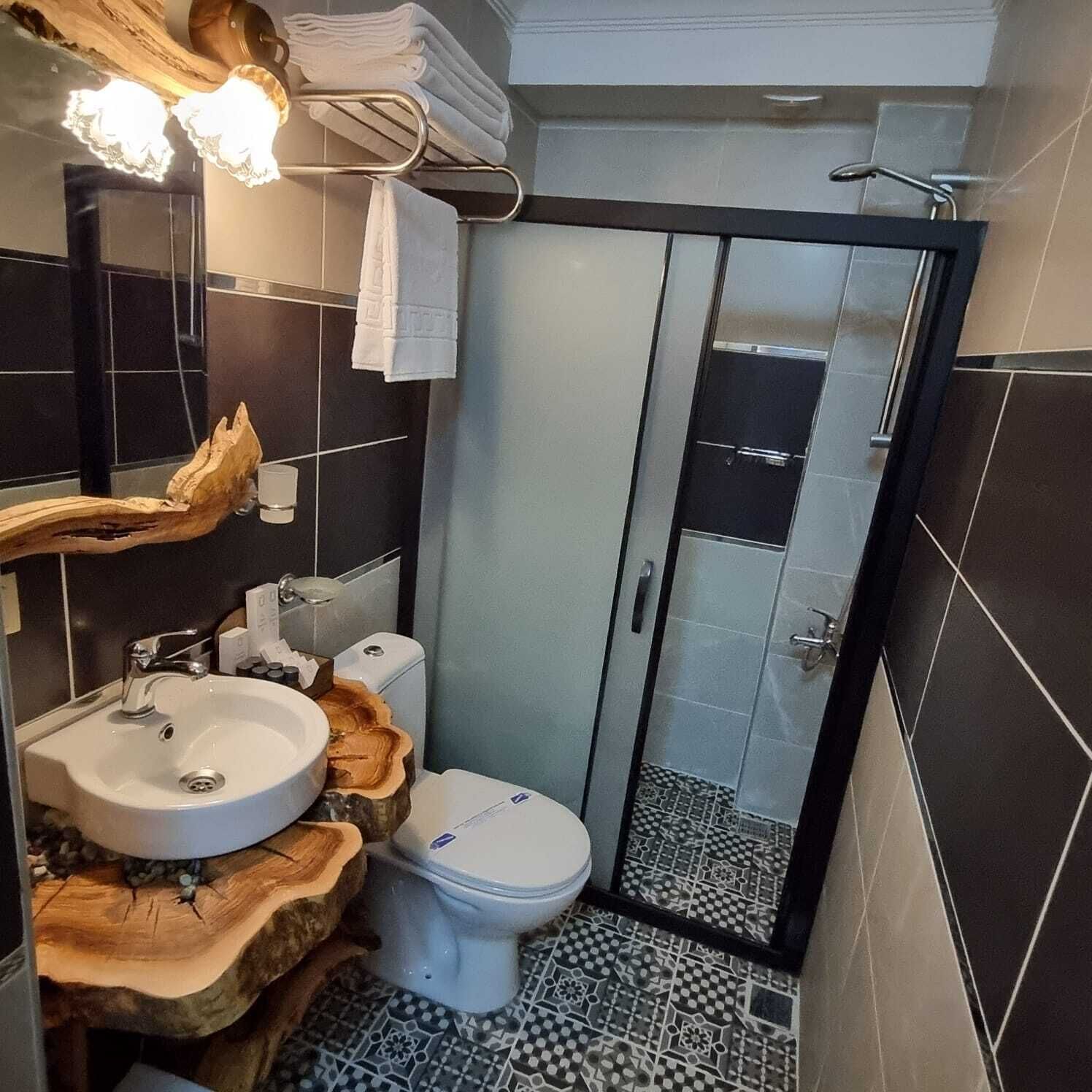 Un baño con lavamanos, inodoro y ducha.