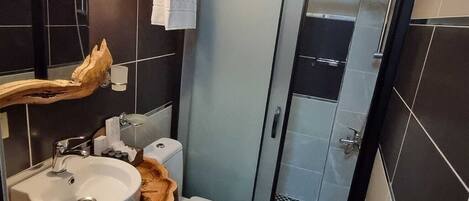 Un baño con lavamanos, inodoro y ducha.