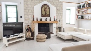 Ein Wohnzimmer mit Fernseher, Sofa, Kamin und Backsteinwand.