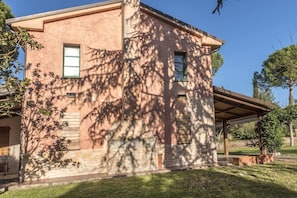 A two-story building with a stone facade, large windows, and a covered patio area.