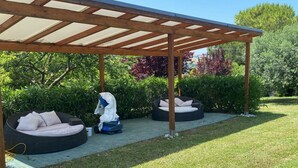 Ein überdachter Außenbereich mit zwei runden Sitzsäcken und einer Holzw pergola.