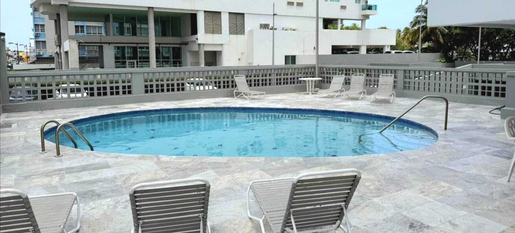 Una piscina con sillas de descanso y un deck empinado.