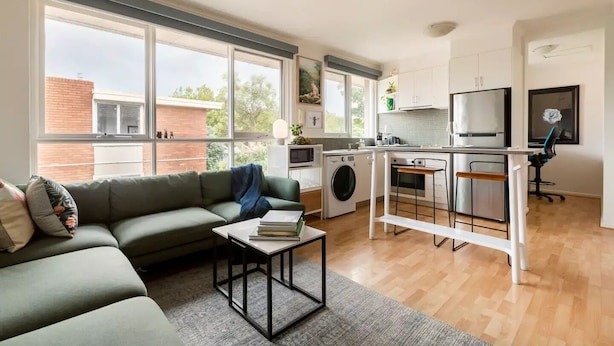 Um apartamento moderno com sala de estar, cozinha e área de lavanderia.