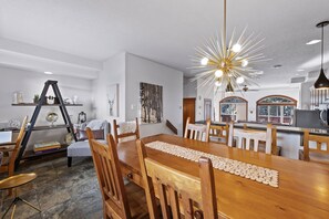 A dining area with a wooden table, chairs, and a decorative ceiling light.