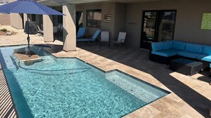 Une piscine avec des chaises longues et un canapé bleu.