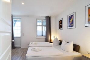 A hotel room with two beds, a window, and three framed pictures on the wall. - The house Ahlbeck - beautiful 80sqm - Remise (restored in 2023) - Villa (Heringsdorf)