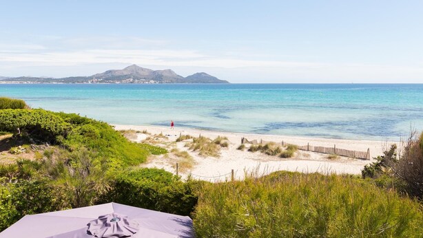 Une plage offrant une vue dégagée sur la mer et les montagnes lointaines.