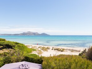 Une plage offrant une vue dégagée sur la mer et les montagnes lointaines.