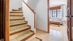 Un escalier menant à un espace de vie comprenant un canapé et une fenêtre.