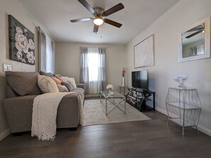 Relax in this stylish living room with a flat-screen TV, comfortable sofa, and beautiful artwork.