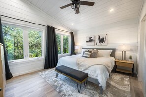 A bedroom with a bed, bench, bedside table, and a ceiling fan. - NEW Luxe Cabin/4 Private King Bedrooms/Firepit/Creek Nearby/Air Hockey/Arcades (Broken Bow)